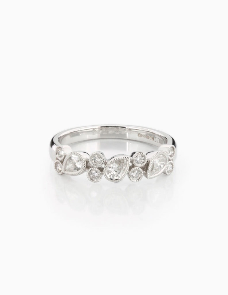 18ct white gold ring set with alternating pear-shaped and round diamonds in milgrain bezel settings