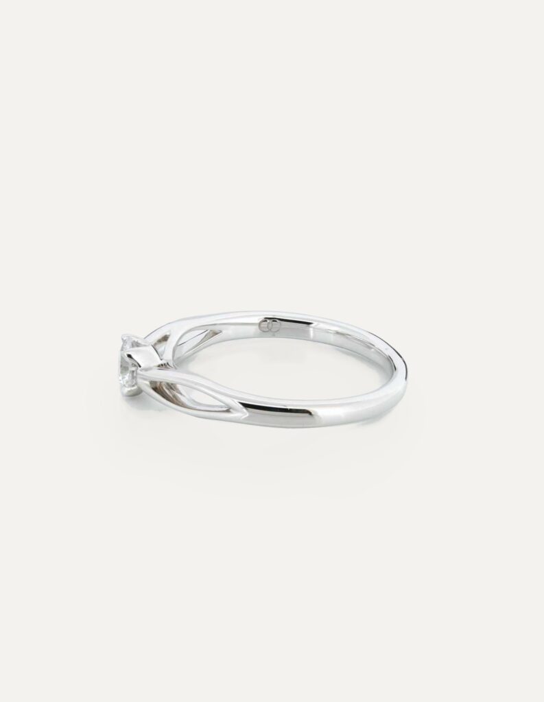 Side view of a platinum solitaire ring with a 4-claw set princess-cut diamond