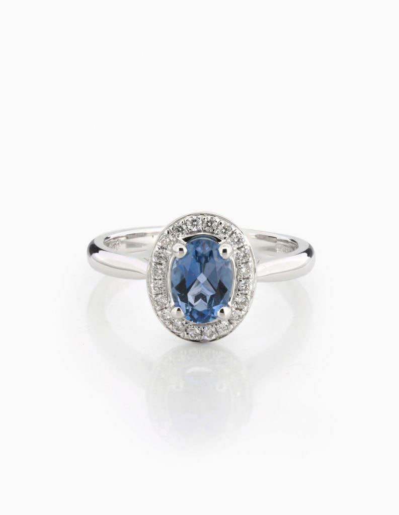 18ct white gold halo ring with an oval aquamarine framed by a round diamond halo