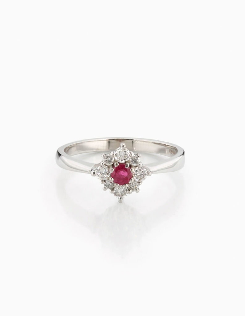 Ruby and diamond cluster ring with a central round ruby framed by round brilliant diamonds in white gold