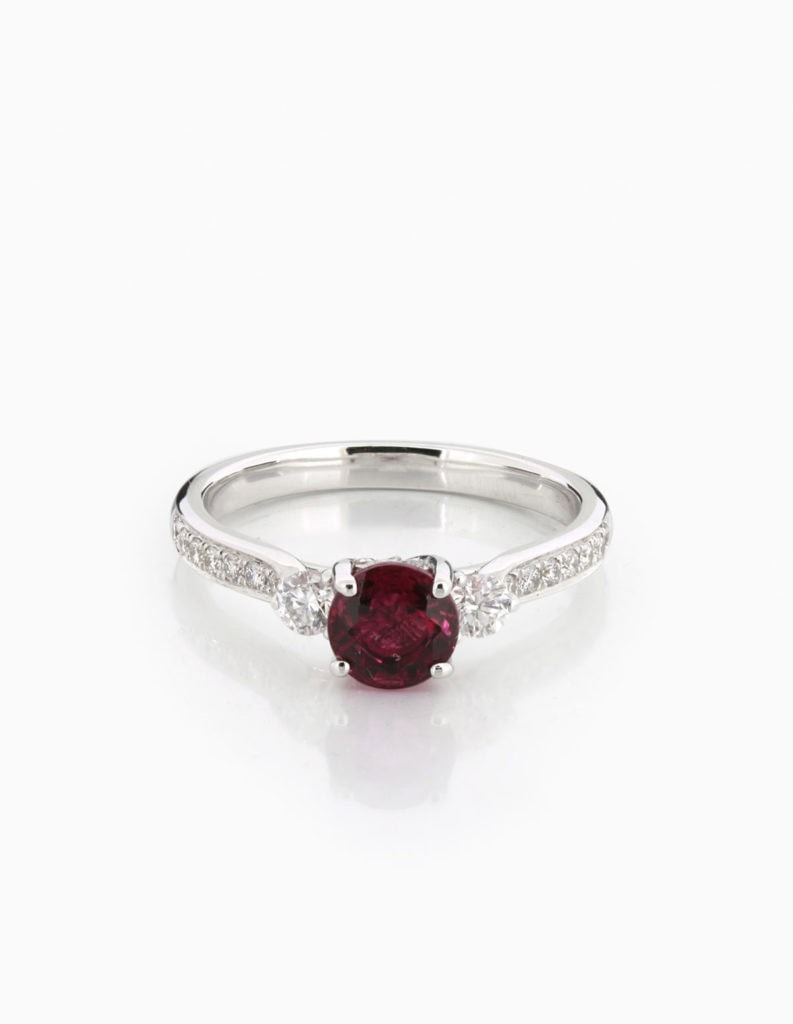 18ct white gold trilogy ring with a round pink-red tourmaline centre stone, diamond sides, and pave diamond shoulders