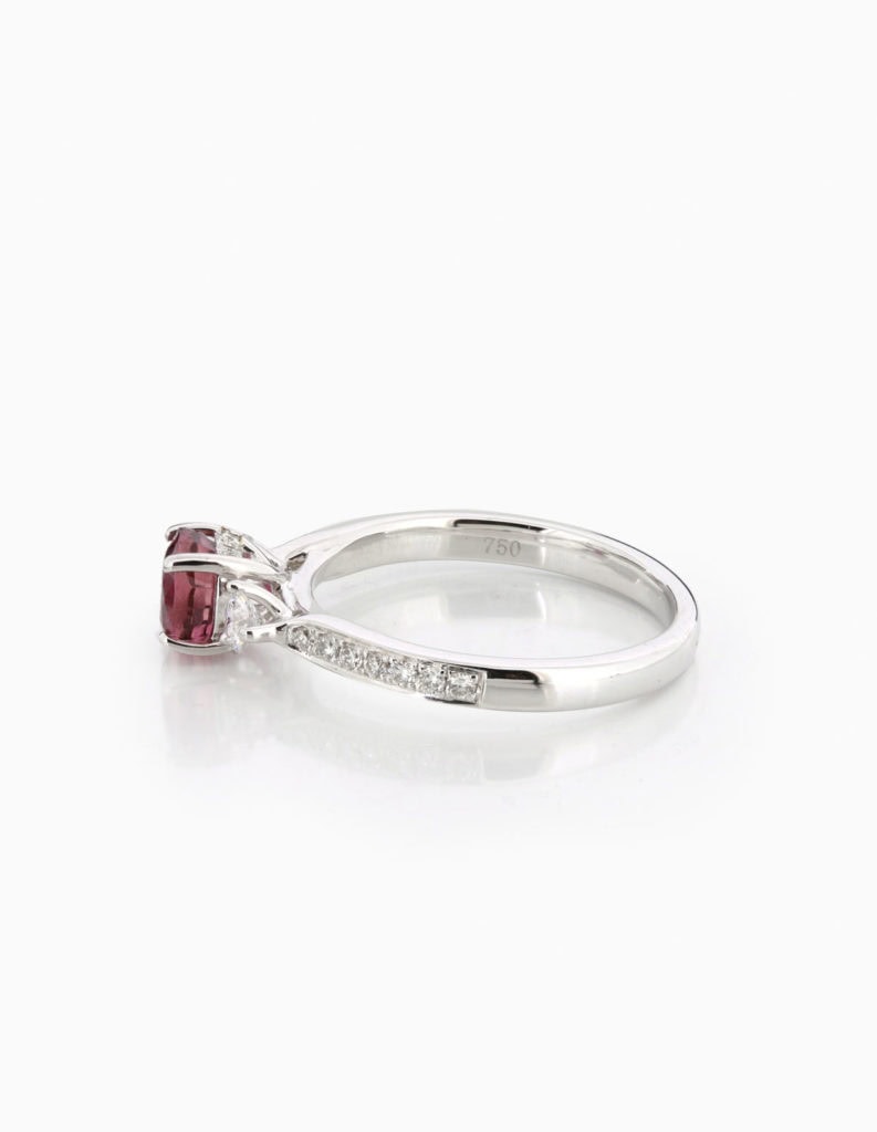 Side view of an 18ct white gold trilogy ring with a pink-red tourmaline and diamond sides