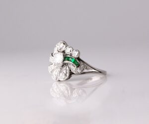 Dress ring fan design with round centre diamond 0.50ct other diamond details 0.76ct with smal emeralds 0.15ct platinum ring size N — side view