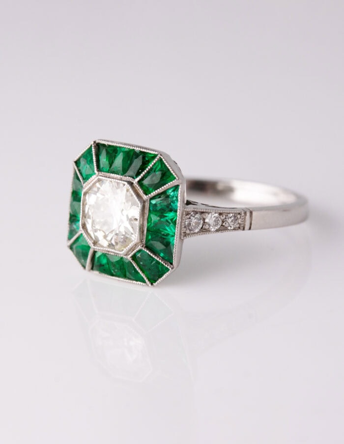 Dress ring art deco style centre roud diamond 1.30ct surrounded by Emeralds 0.90ct Platinum ring size O — side view