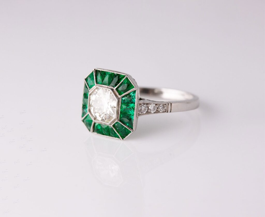 Dress ring art deco style centre roud diamond 1.30ct surrounded by Emeralds 0.90ct Platinum ring size O — side view