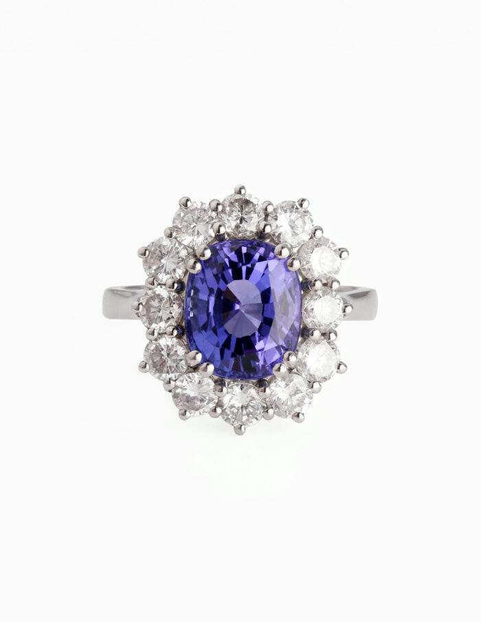 Large blue stone cluster ring with a surrounding halo of diamonds