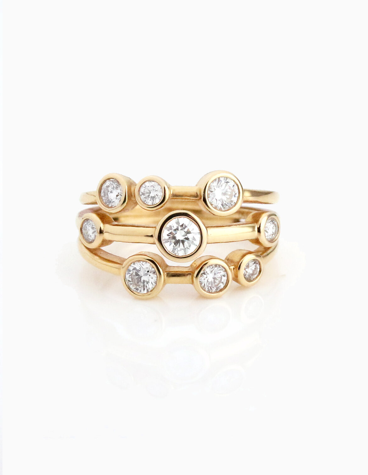 Yellow Gold Ring with 3 strands of gold featuring various size diamonds in a bezel setting