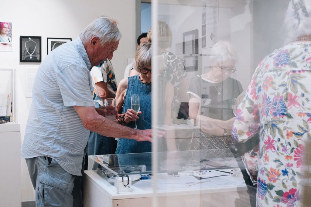 Visitors viewing jewellery at The Jewellery Workshop's 50th anniversary exhibition