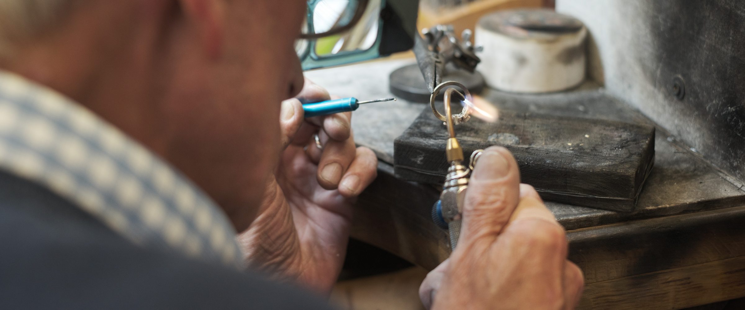 Paul resizing a gold ring with a jeweller’s torch at The Jewellery Workshop bench in Diss
