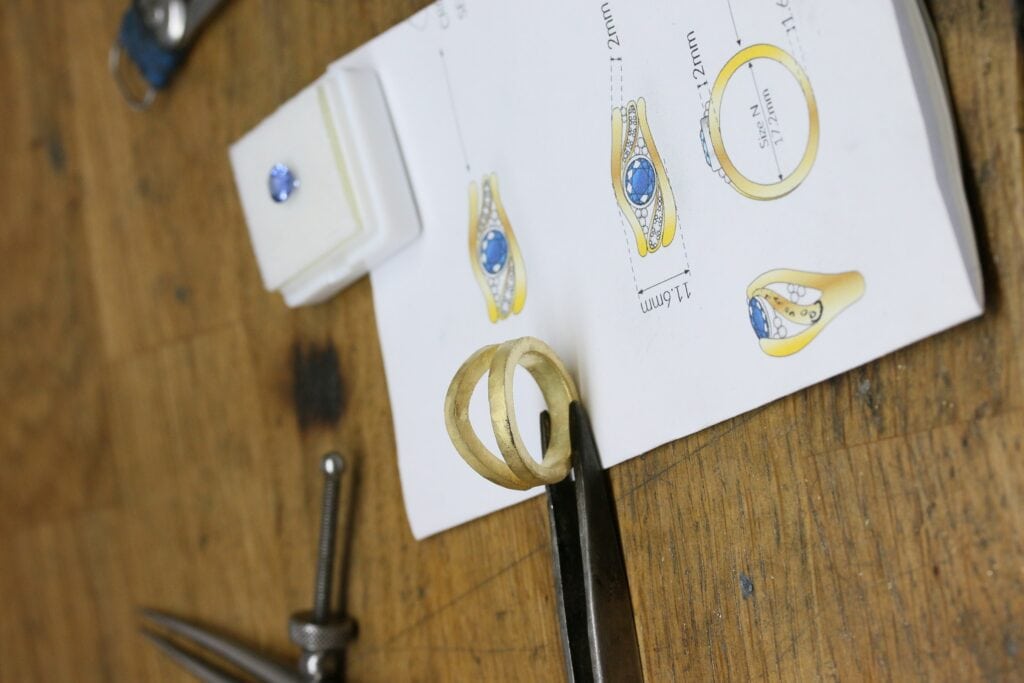 One-off 9ct yellow gold ring with a cushion sapphire and diamond-set shoulders
