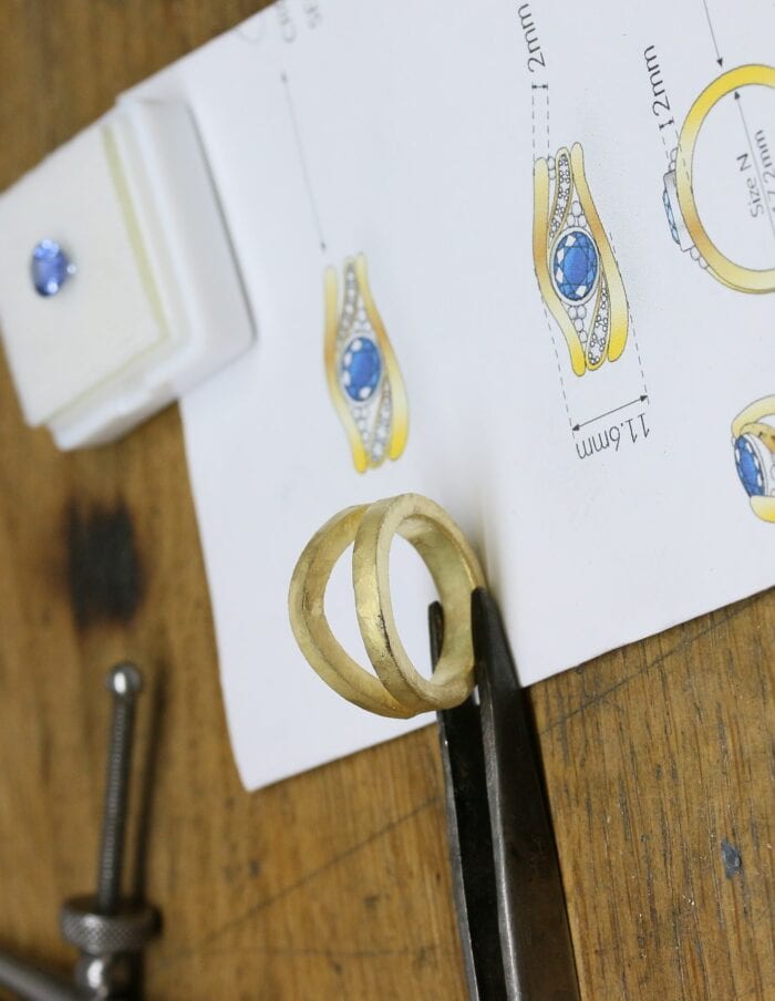 One-off 9ct yellow gold ring with a cushion sapphire and diamond-set shoulders