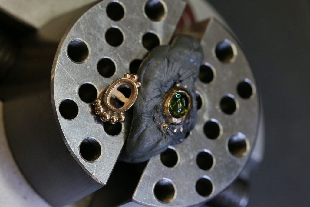 One-off green tourmaline cabochon stud earrings in 9ct yellow gold with bead-set bezels