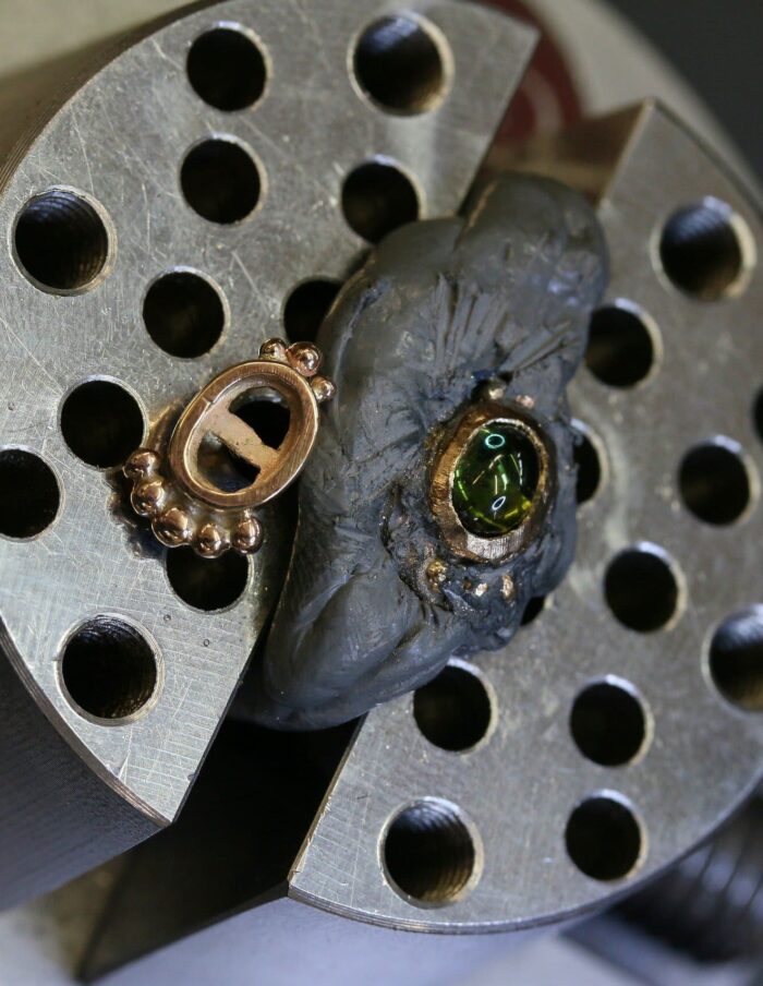 One-off green tourmaline cabochon stud earrings in 9ct yellow gold with bead-set bezels