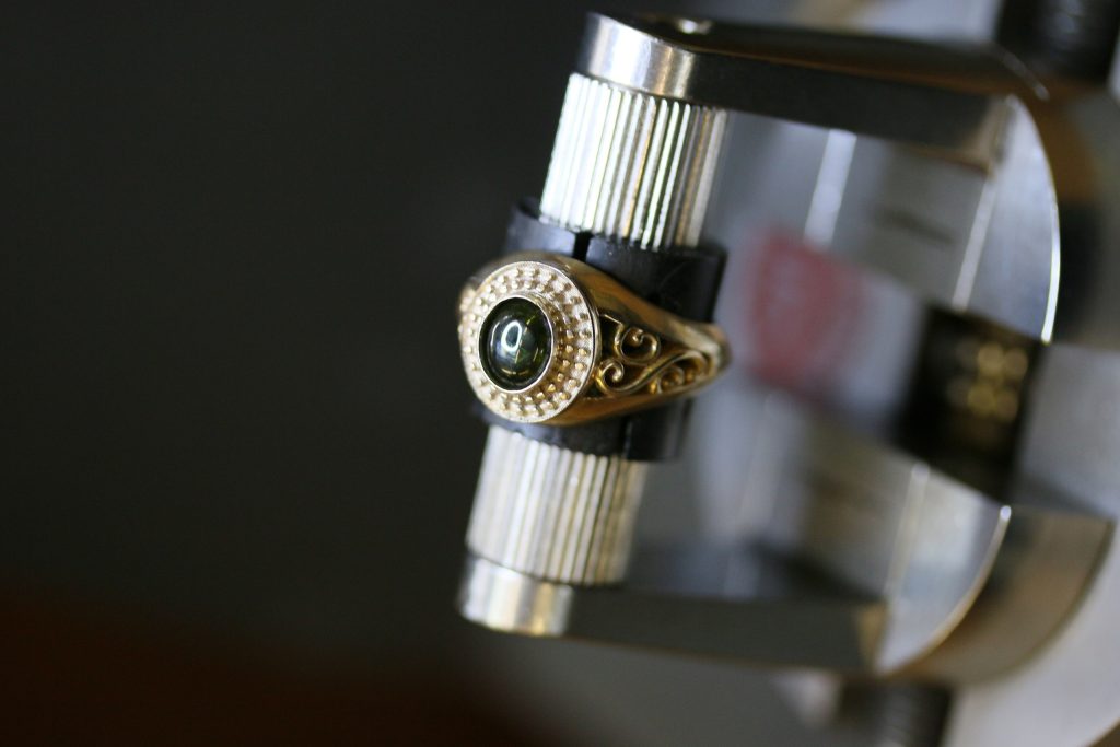 One-off 9ct gold signet ring with a green tourmaline cabochon in a diamond halo